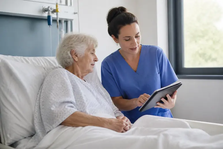 Une infirmière française montre une tablette à un patient âgé pour expliquer le score qSOFA.