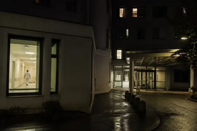Entrée d'un hôpital français la nuit, montrant le contexte des gardes pour le salaire IADE.