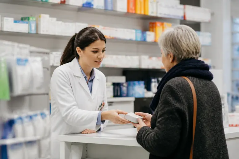 Technicien en pharmacie conseillant un client, discussion du salaire pharmacien officine.