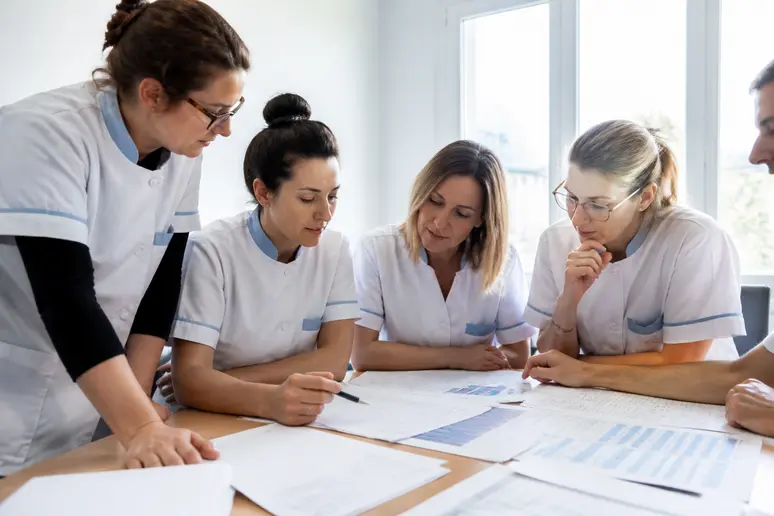 Puéricultrices françaises examinant des grilles salariales en 2026, discussion sur la rémunération.