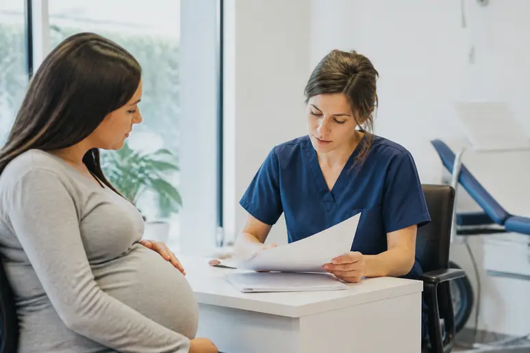 Un médecin examine le score de Bishop pour interpréter la maturité cervicale avant un accouchement.